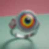 A close-up view of a colorful googly eye ring on a vibrant background