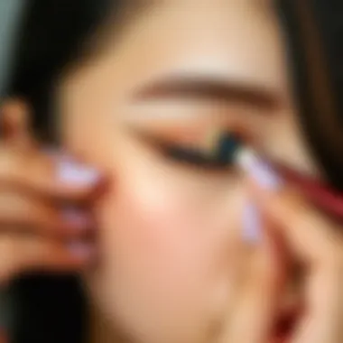 Close-up of a hand applying cream eyeshadow on eyelid.