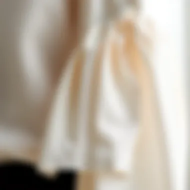 Close-up of intricate fabric detailing on a white bell sleeve blouse