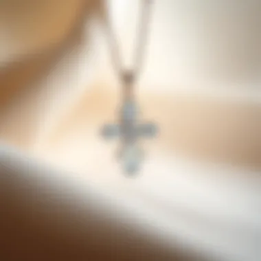 A stylish moissanite cross pendant on a delicate chain displayed against a soft fabric background