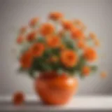 Vibrant orange faux flowers arranged in a stylish vase